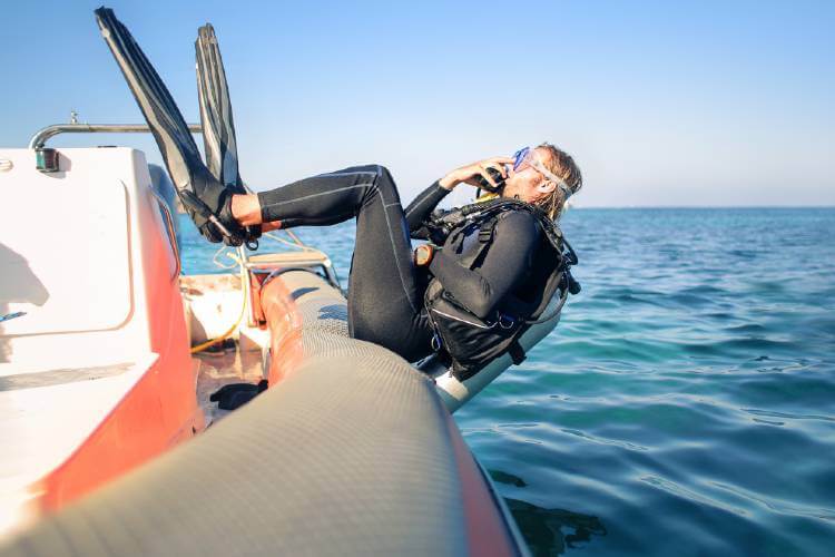 scuba diver diving backwards off the boat